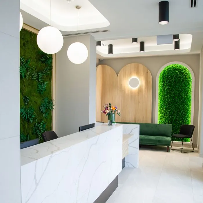 Reception area at Yonge Forest Dental with a marble desk and moss-lined arches