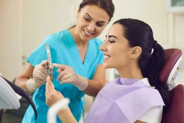 Dentist showing a dental implant model to a patient at Yonge Forest Dental in Barrie